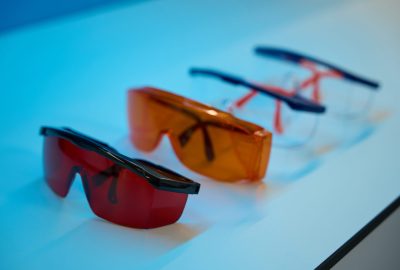 Dental goggles with brown and clear glass lie on the table. Dental instruments